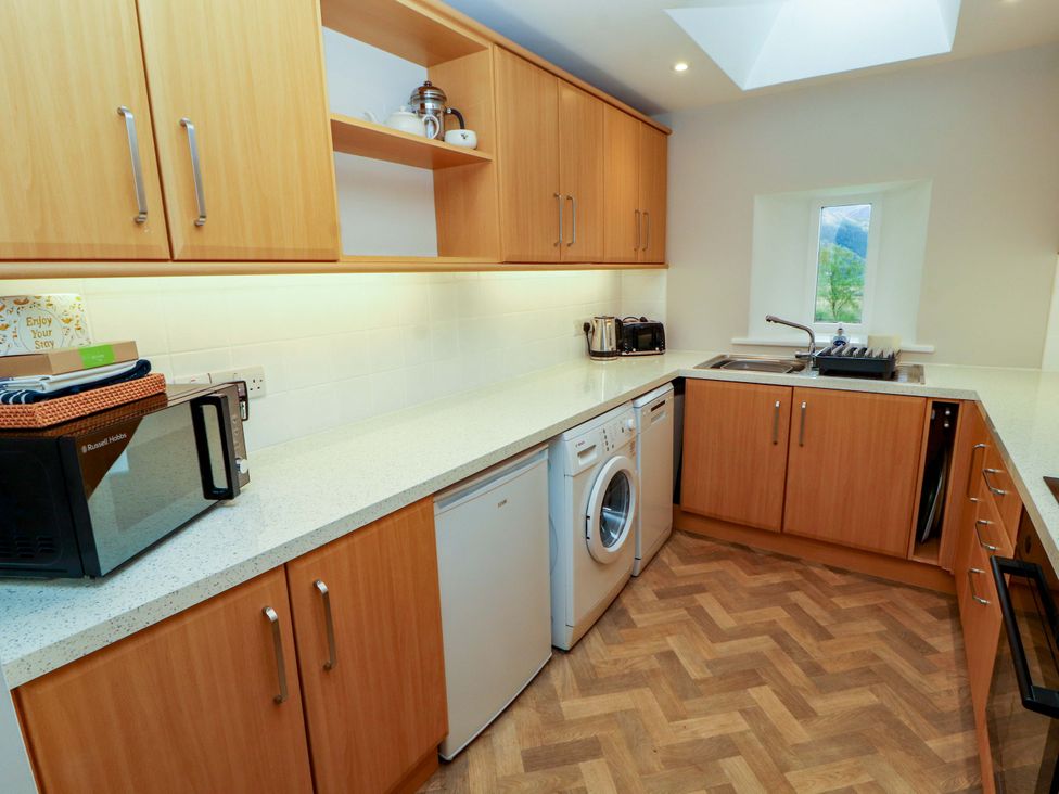 A kitchen with appliances and wooden cabinetry at Swallow's Nest Thornthwaite near Braithwaite