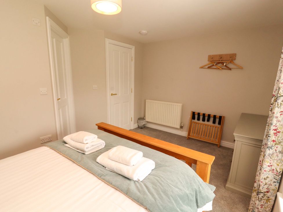 A bedroom with a bed and towels at Swallow's Nest in Thornthwaite near Braithwaite