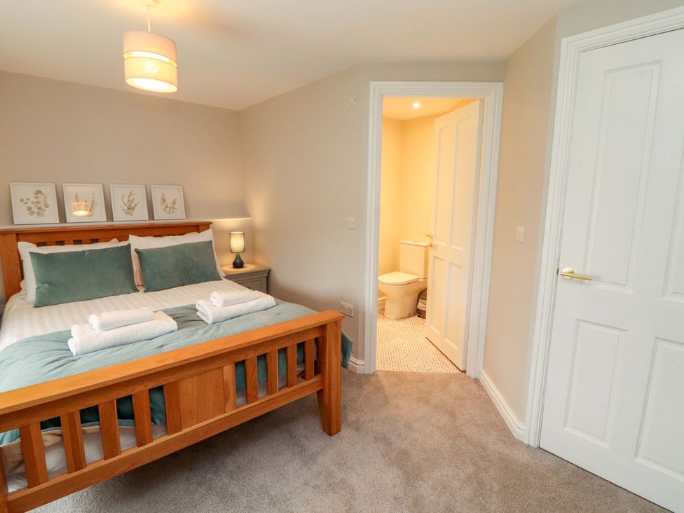 A bedroom with a bed and an en-suite bathroom at Swallow's Nest Thornthwaite near Braithwaite