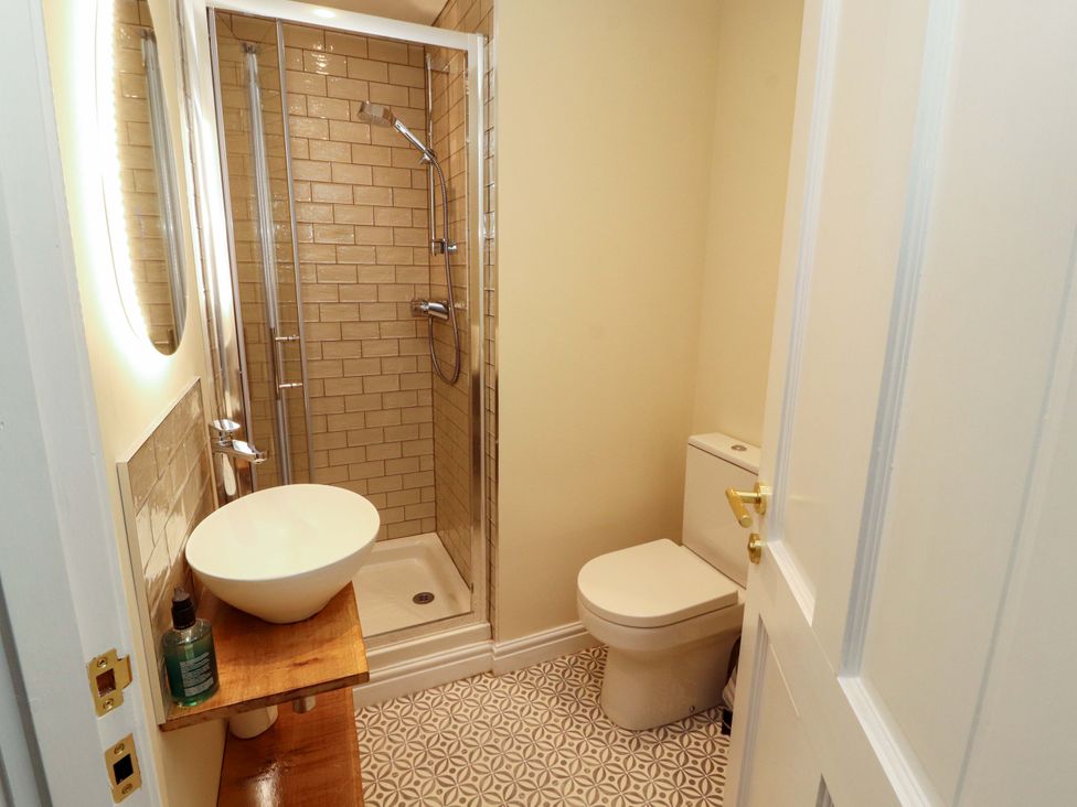 A bathroom with a shower and sink at Swallow's Nest Thornthwaite near Braithwaite