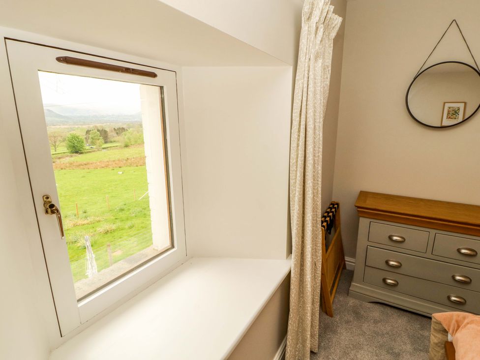 A bedroom with a window and dressing table at Swallow's Nest Thornthwaite near Braithwaite