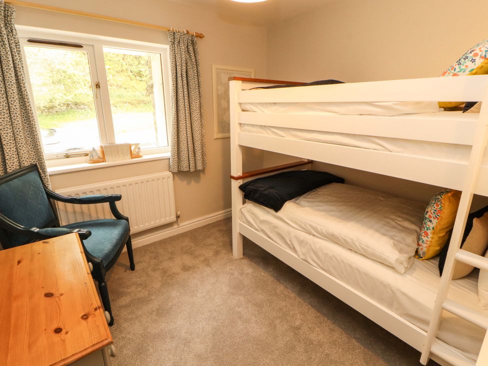 A bedroom with a bunk bed and desk at Swallow's Nest Thornthwaite near Braithwaite