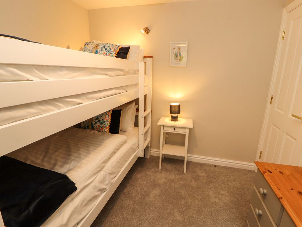 A bedroom with a bunk bed and nightstand at Swallow's Nest in Thornthwaite near Braithwaite