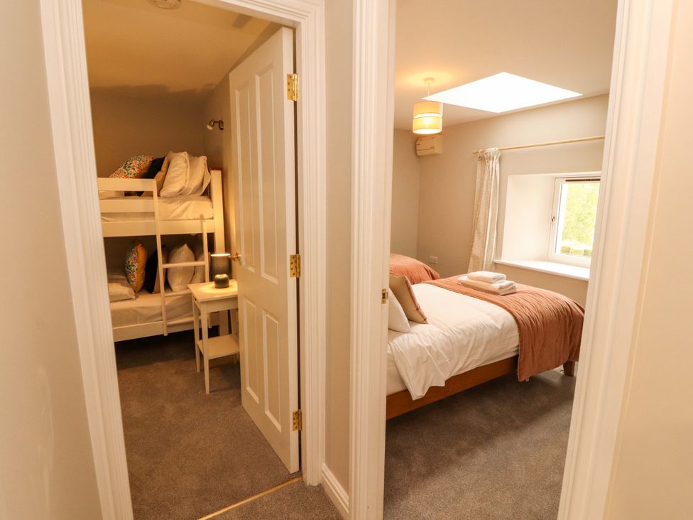 A bedroom with a bunk bed and a double bed at Swallow's Nest Thornthwaite near Braithwaite