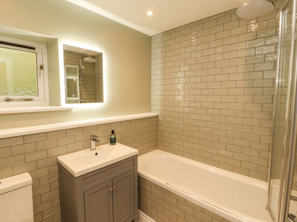 A bathroom with a bathtub and sink at Swallow's Nest in Thornthwaite near Braithwaite