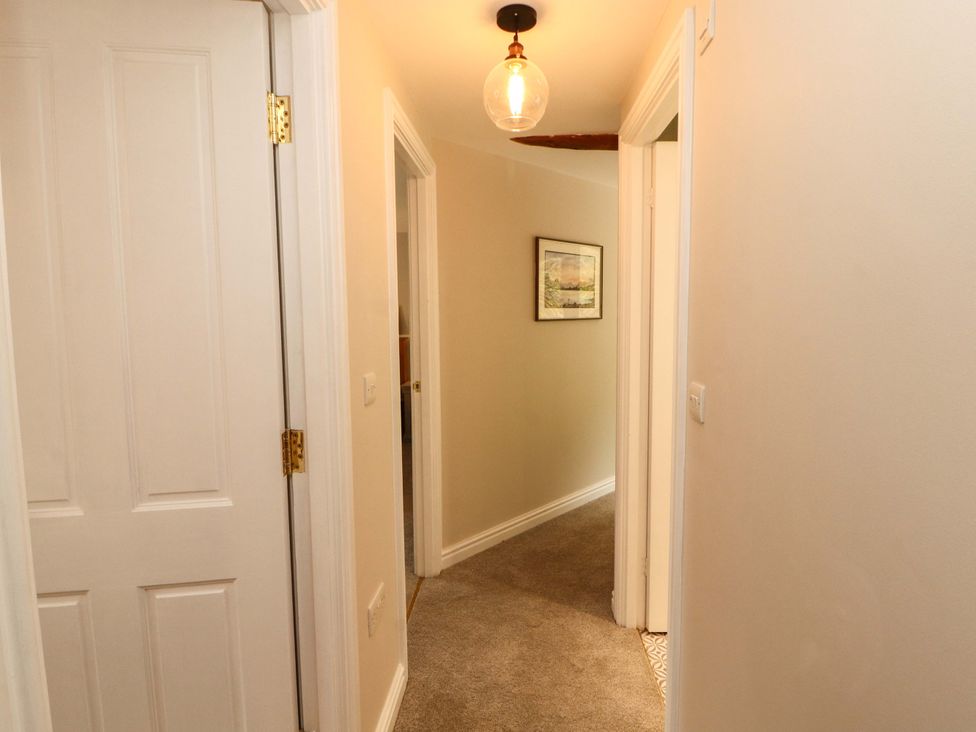 A hallway with doors and a light fixture at Swallow's Nest Thornthwaite near Braithwaite