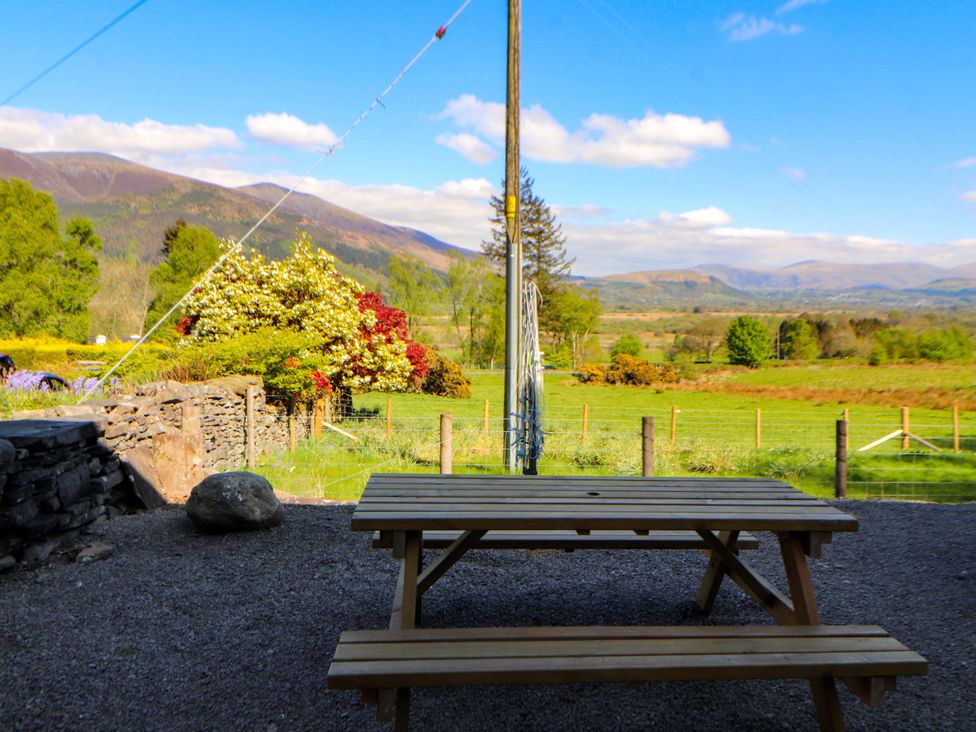An outdoor area with a wooden table and views of mountains at Swallow's Nest in Thornthwaite near Braithwaite