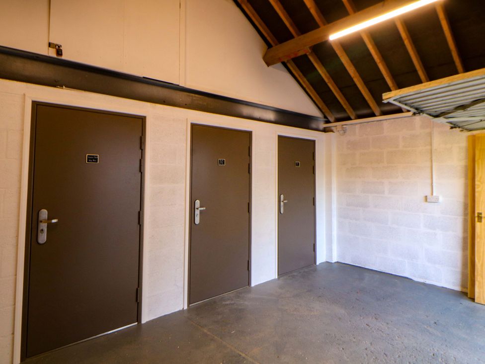 A hallway with doors leading to rooms at Swallow's Nest Thornthwaite near Braithwaite