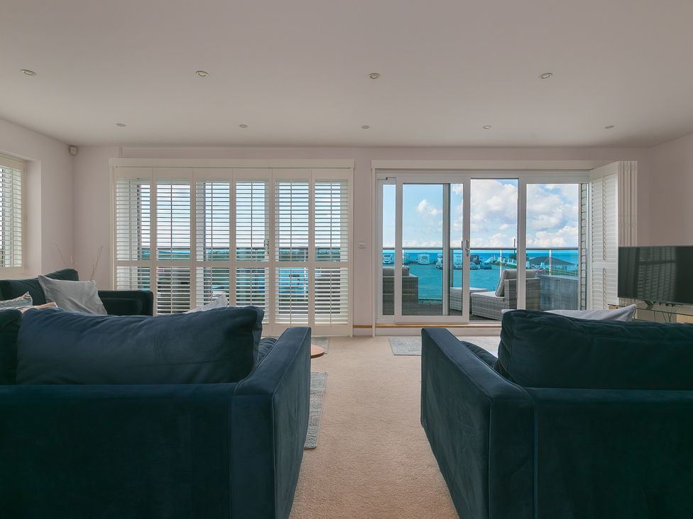 A living room with sofas and balcony view at Sandbanks in Praa Sands