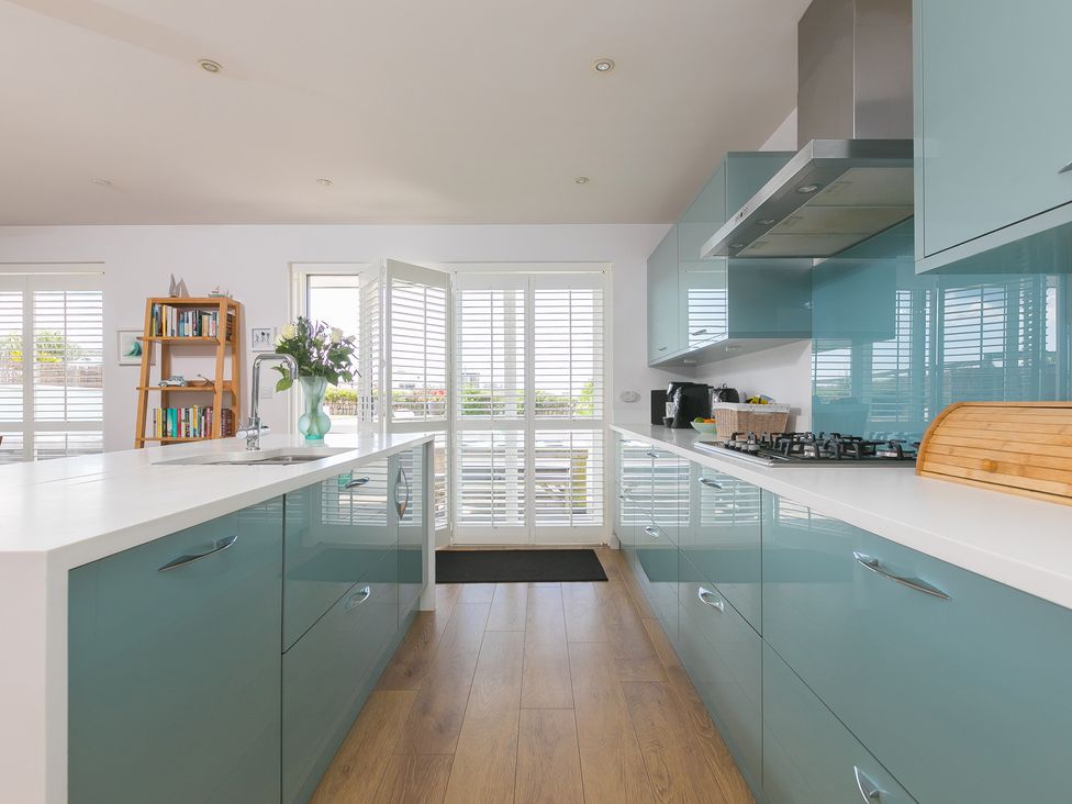 A kitchen with cabinets and a gas stove at Sandbanks in Praa Sands
