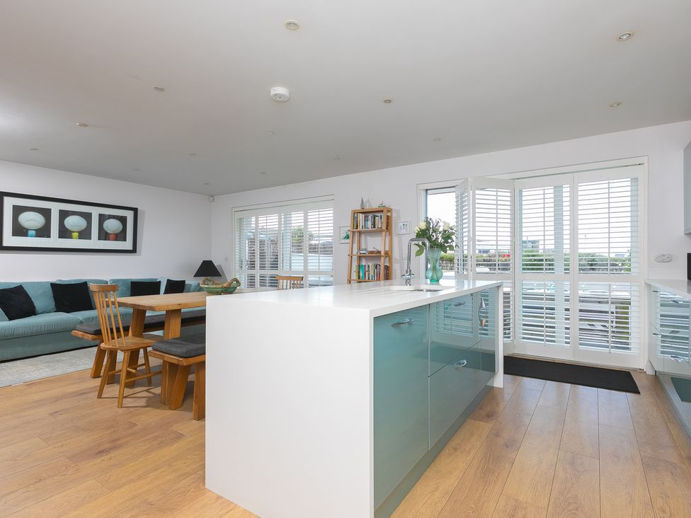 A kitchen and living room area with furniture at Sandbanks in Praa Sands