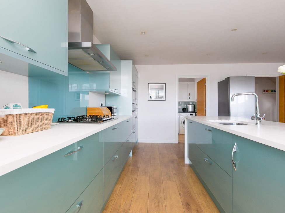 A kitchen with cabinets and appliances at Sandbanks in Praa Sands