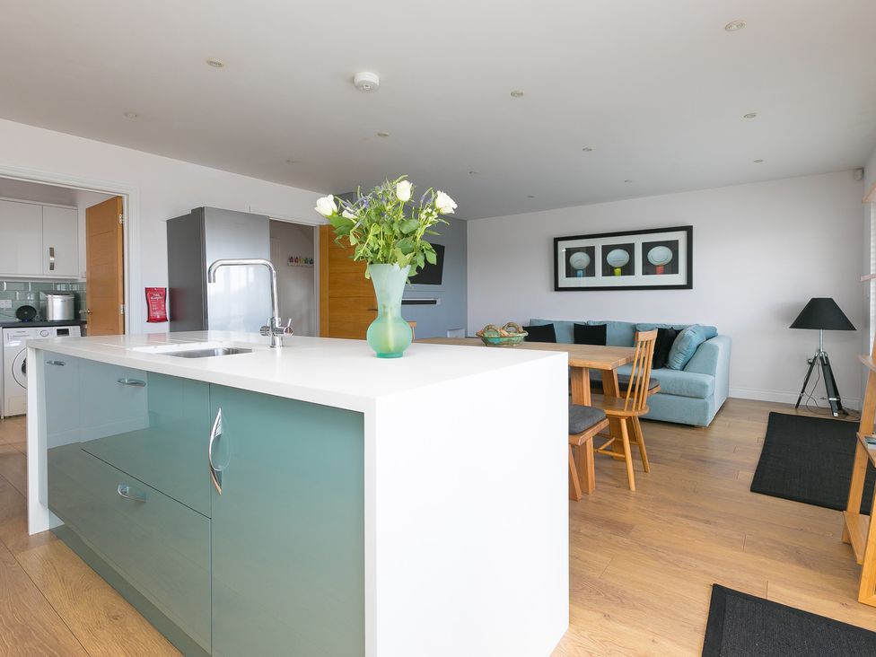 A kitchen with a dining area and living space at Sandbanks in Praa Sands
