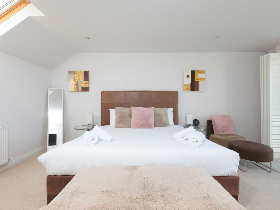 A bedroom with a bed and mirror at Sandbanks in Praa Sands
