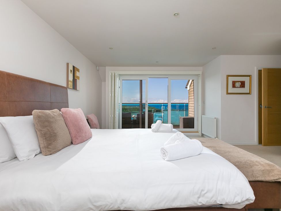 A bedroom with a bed and sliding doors at Sandbanks in Praa Sands