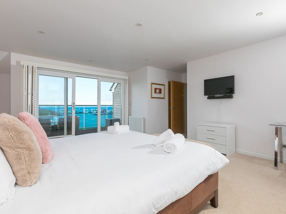 A bedroom with a bed and television at Sandbanks in Praa Sands
