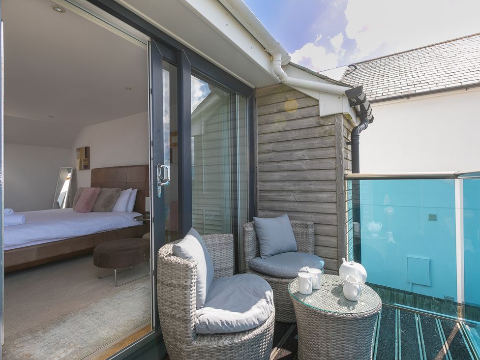 A balcony with chairs and a table at Sandbanks, Praa Sands
