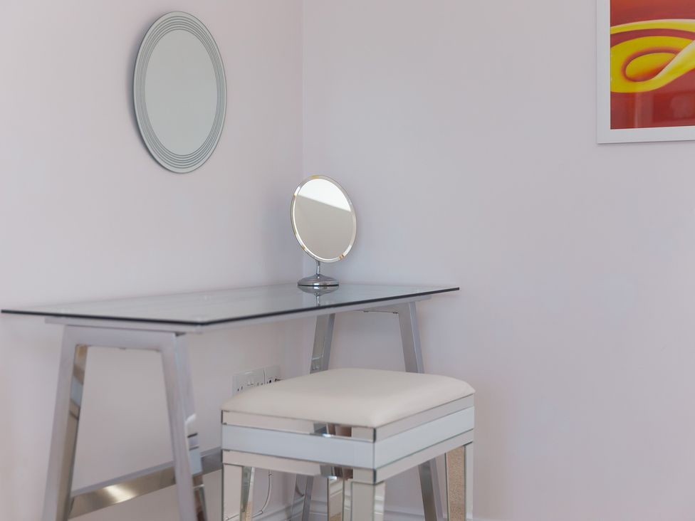 A dressing room with a vanity table and mirror at Sandbanks in Praa Sands