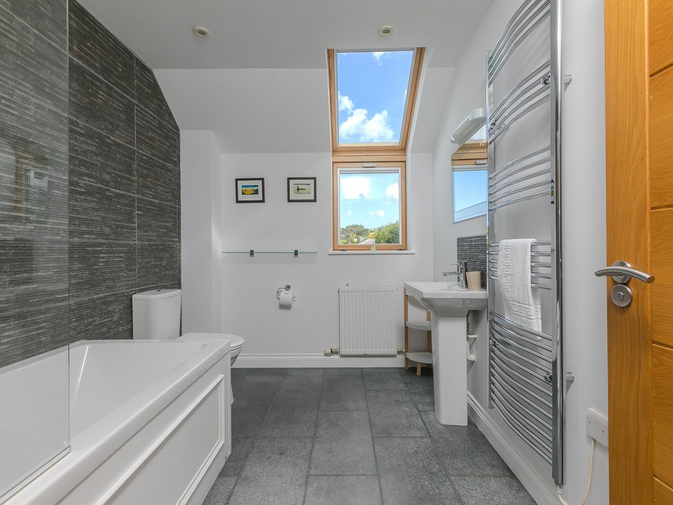 A bathroom with a bathtub, toilet, and sink at Sandbanks, Praa Sands