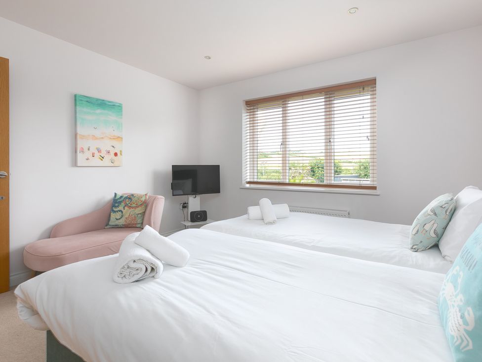 A bedroom with two single beds and a TV at Sandbanks in Praa Sands