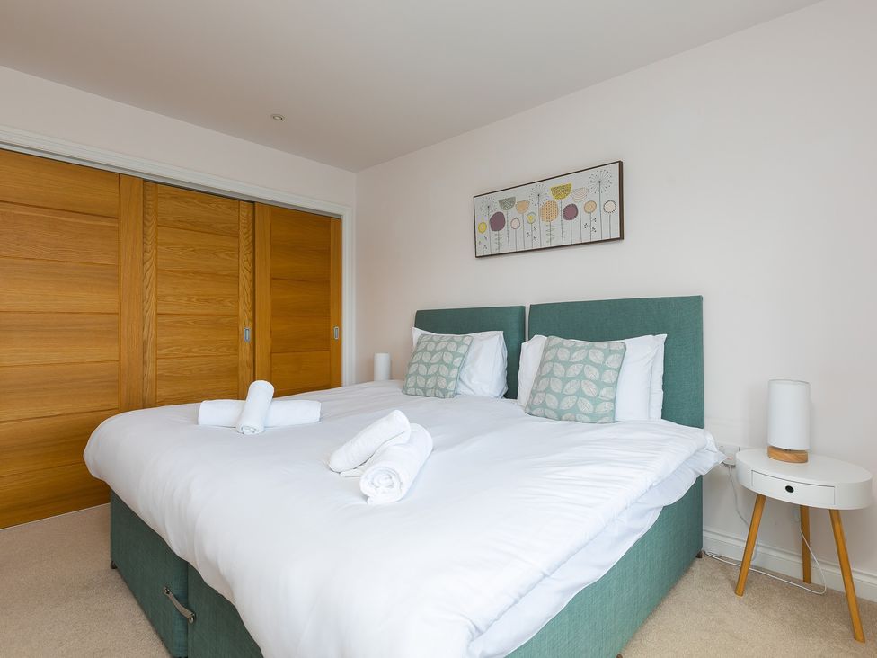 A bedroom with a bed and a nightstand at Sandbanks in Praa Sands
