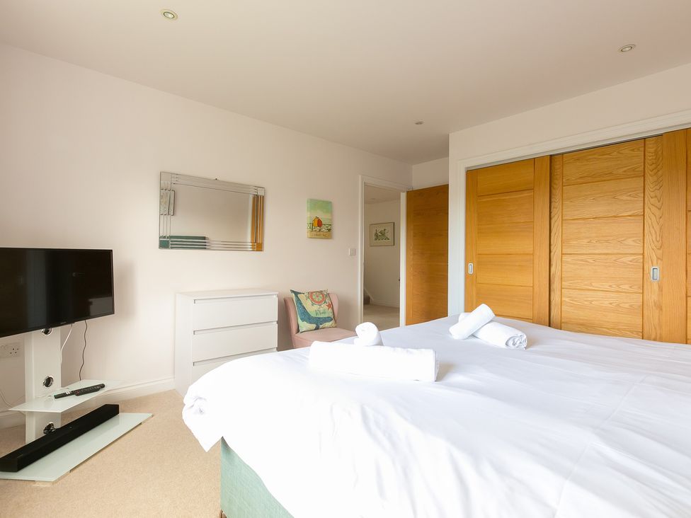A bedroom with a bed and television at Sandbanks in Praa Sands