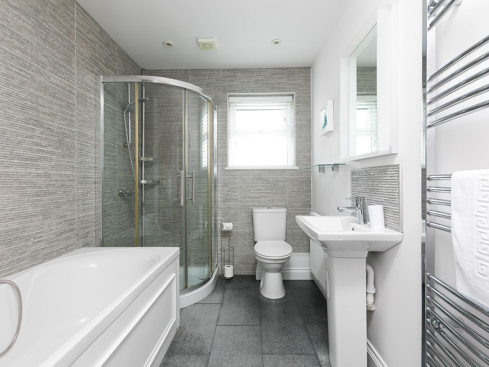 A bathroom with shower, bathtub, sink and toilet at Sandbanks in Praa Sands