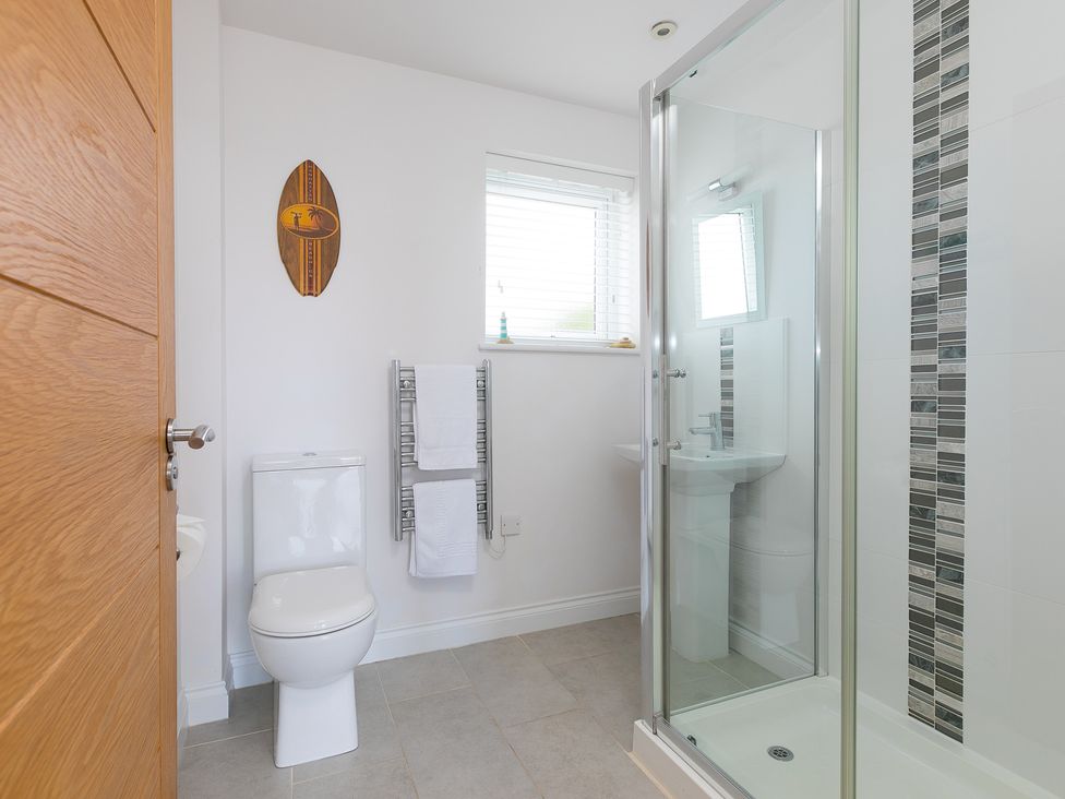 A bathroom with a shower and toilet at Sandbanks in Praa Sands