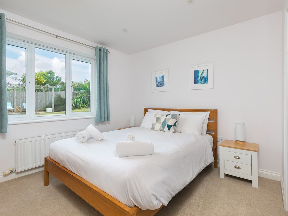 A bedroom with a bed and window at Sandbanks in Praa Sands
