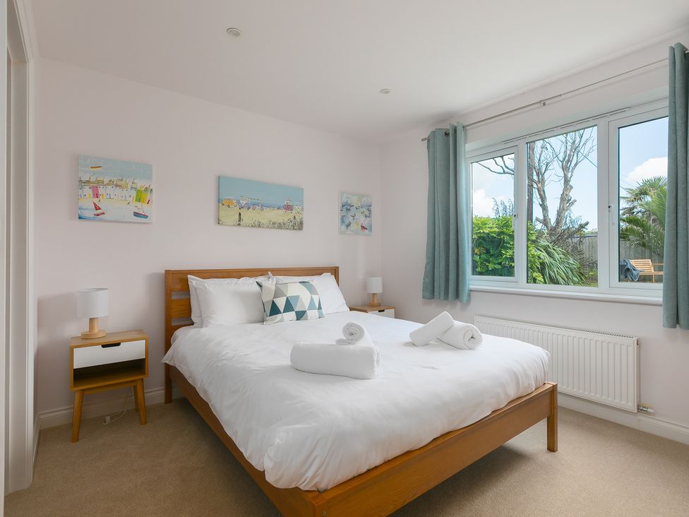 A bedroom with a bed and lamp at Sandbanks in Praa Sands