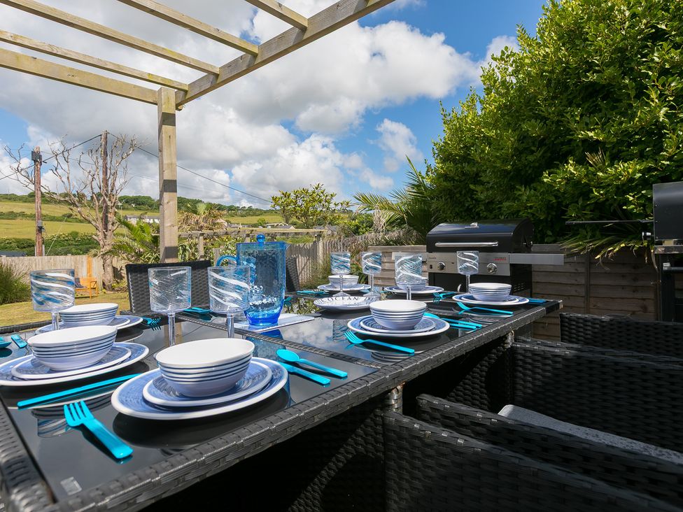 An outdoor dining area with table set for a meal at Sandbanks in Praa Sands