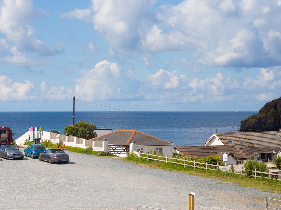 A view of the sea with houses and vehicles at Sandbanks in Praa Sands
