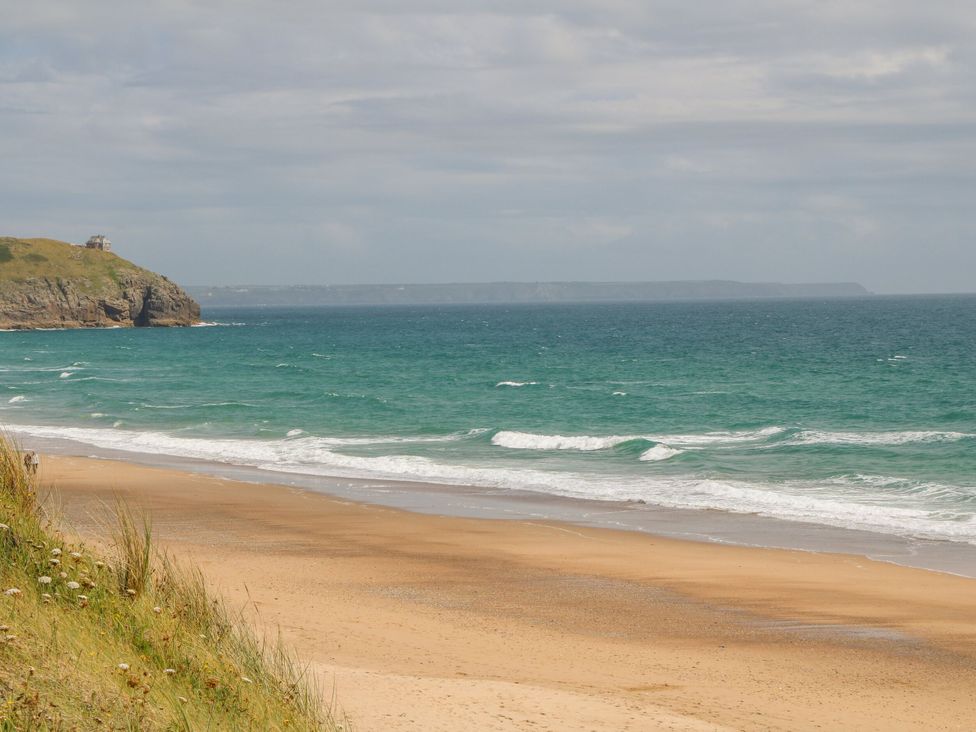 A beach with waves and cliffs at Sandbanks in Praa Sands