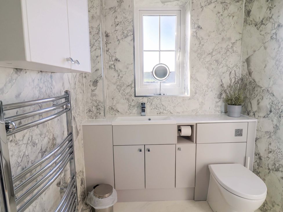 A bathroom with a sink and toilet at West Bay Holiday Home in West Bay