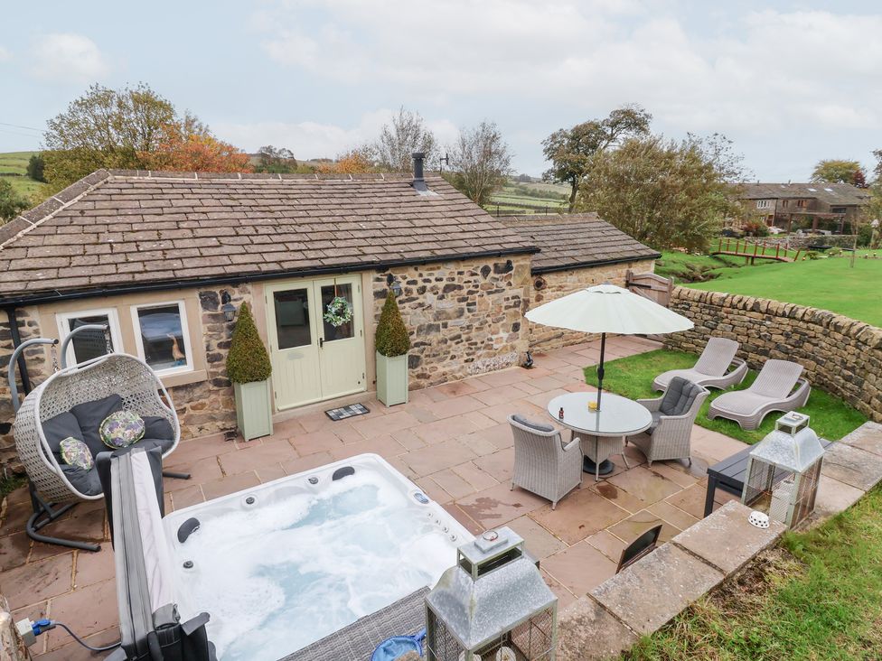 A garden with a hot tub and outdoor seating at Beckside Cottage in Cowling near Skipton