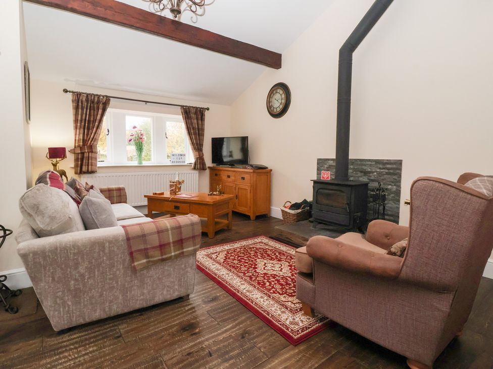 A living room with a sofa and television at Beckside Cottage in Cowling near Skipton
