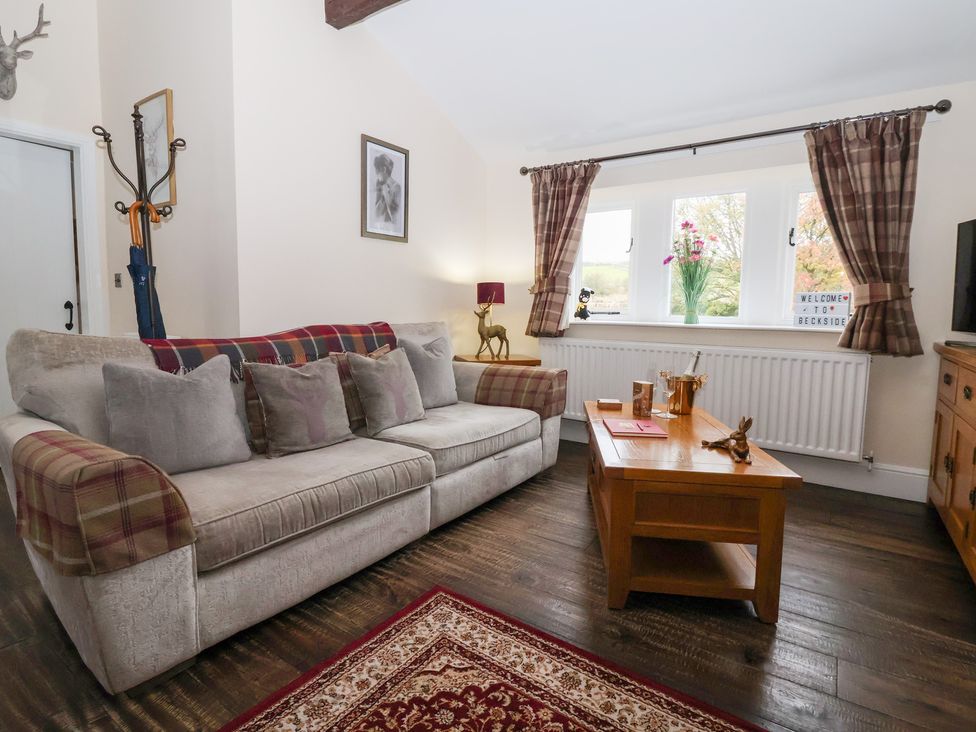 A living room with a sofa and coffee table at Beckside Cottage in Cowling near Skipton