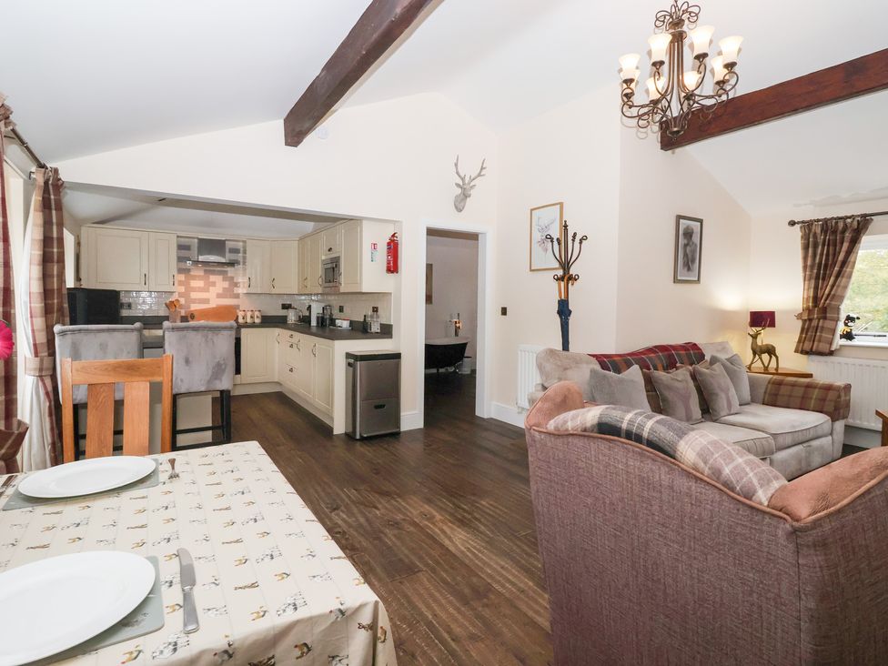 A living room and kitchen setup with a dining table at Beckside Cottage in Cowling near Skipton
