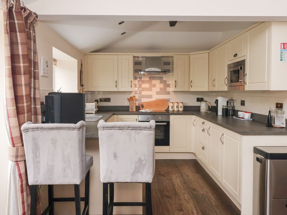 A kitchen with cabinets and appliances at Beckside Cottage in Cowling near Skipton