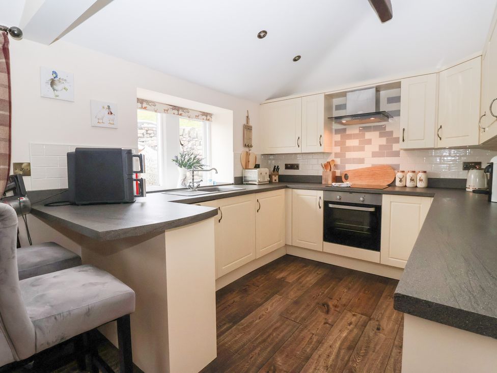 A kitchen with appliances and countertops at Beckside Cottage in Cowling near Skipton