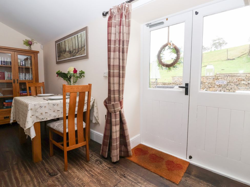 A dining room with a table and chairs at Beckside Cottage in Cowling near Skipton