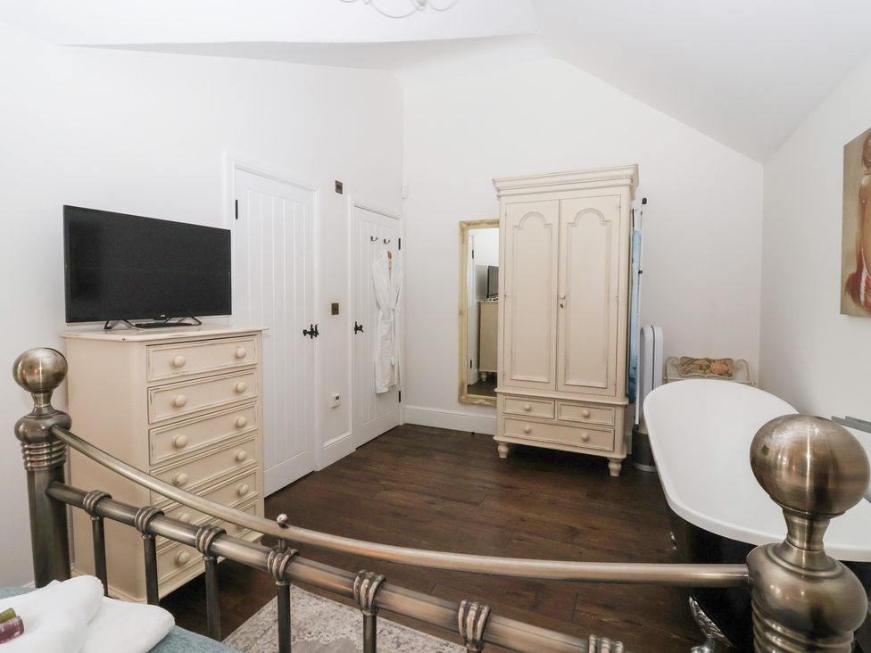 A bedroom with a television and a wardrobe at Beckside Cottage in Cowling near Skipton