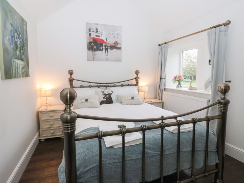 A bedroom with a bed and nightstands at Beckside Cottage, Cowling near Skipton