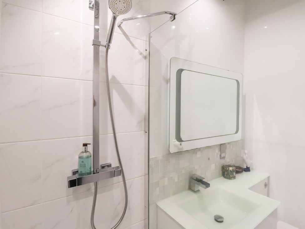 A bathroom featuring a shower and sink at Beckside Cottage Cowling near Skipton