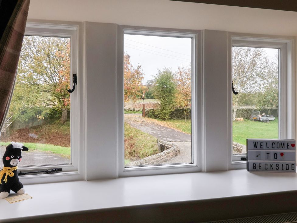 A view from a window with a sign and a toy at Beckside Cottage in Cowling near Skipton