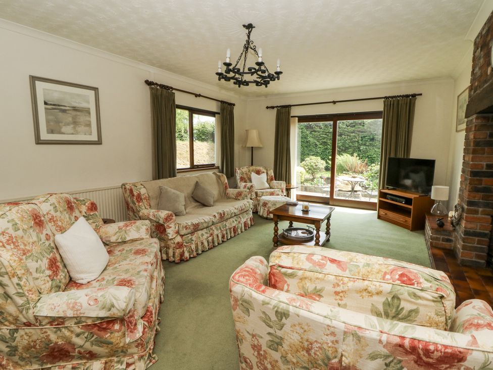 A living room with floral furniture and a television at Kala Spittal near Haverfordwest