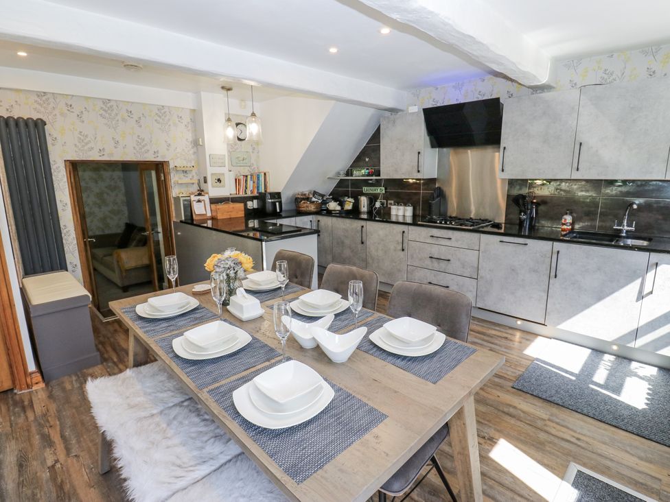 A kitchen with a dining table and modern cabinets at Springhead Cottage in Haworth