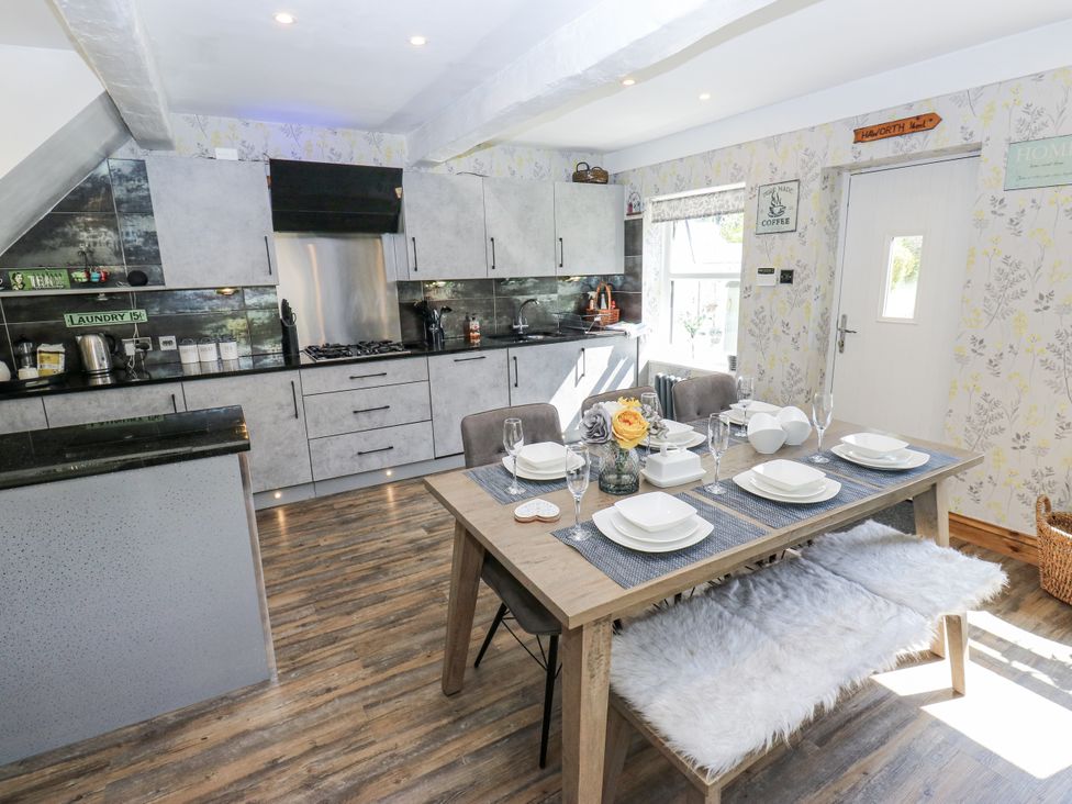 A kitchen with a dining table and chairs at Springhead Cottage in Haworth