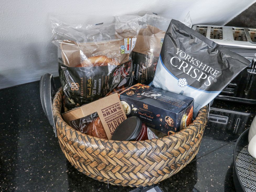A basket with snacks including crisps and cookies at Springhead Cottage in Haworth
