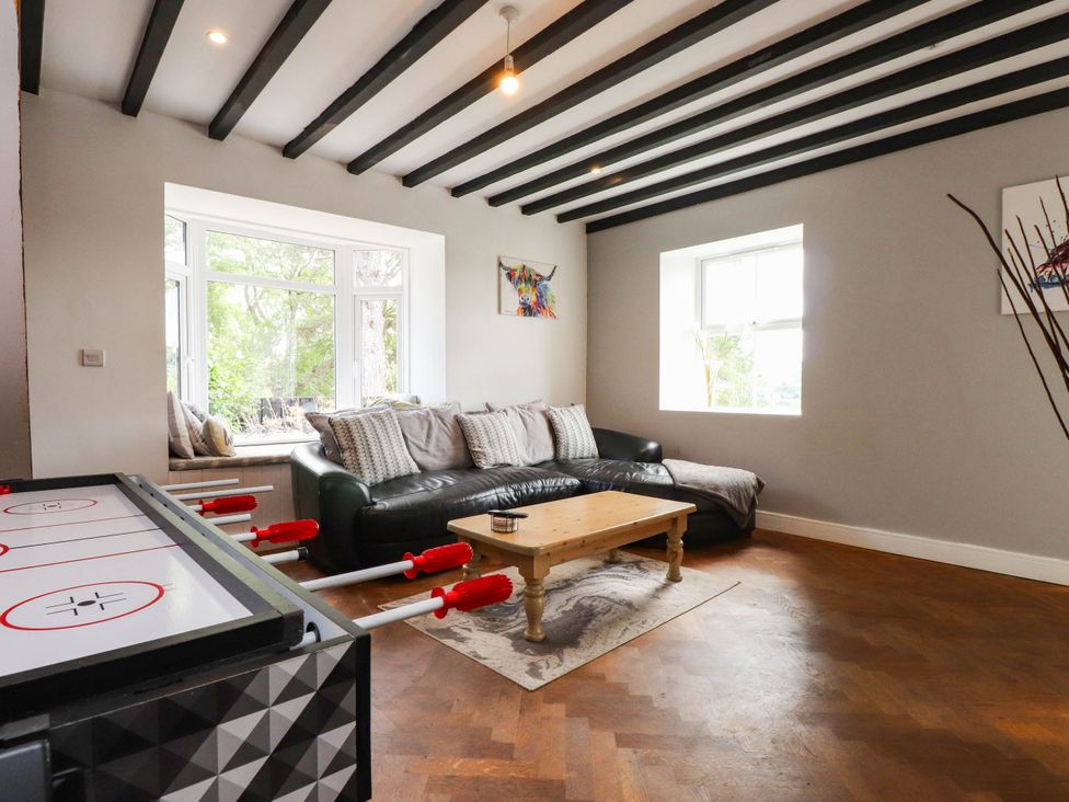 A living room with a sofa and air hockey table at Tyddyn Elidir near Old Colwyn